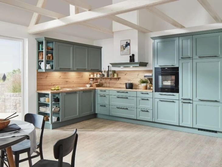 Kitchen interior, light blue cabinetry, oak effect walls, dinner table and garden door