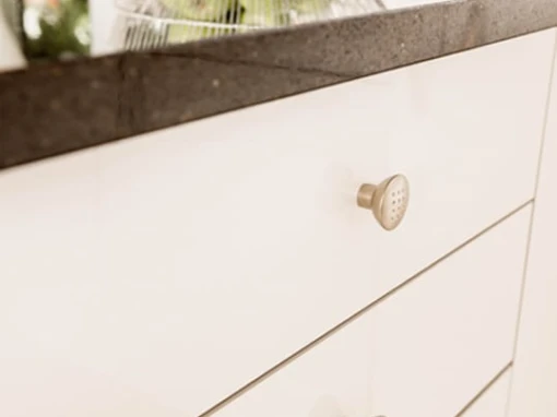 cream acrylic kitchen drawers with gold knob handles